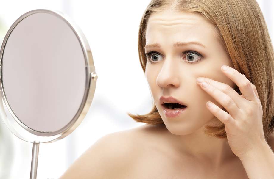 mujer acné espejo